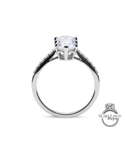 A silver engagement ring with a large central diamond and smaller diamonds on either side.