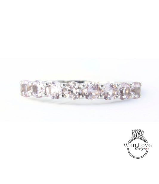 A silver ring with a row of small, clear gemstones, likely diamonds, set in a band.