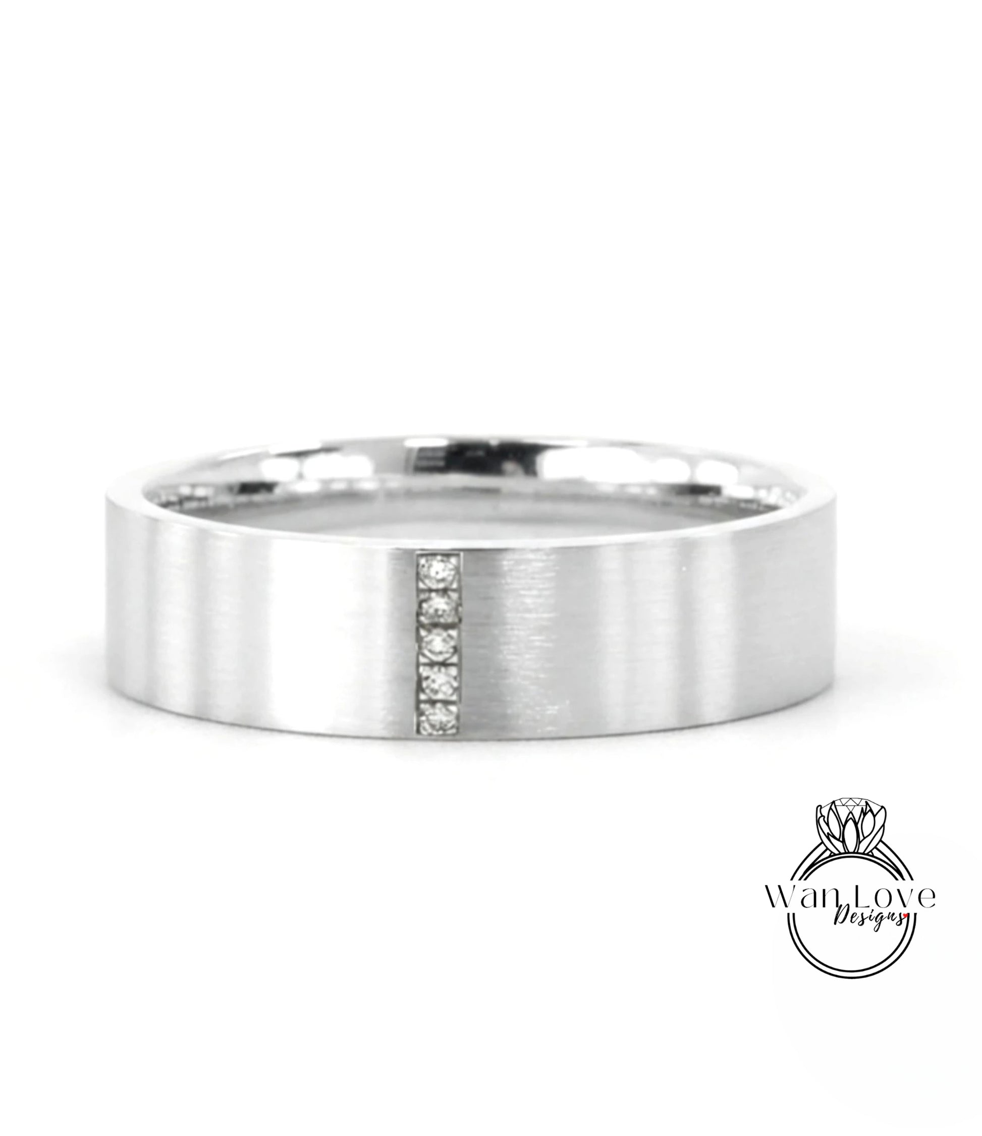A silver-colored ring with a vertical line and three small diamonds embedded in it.