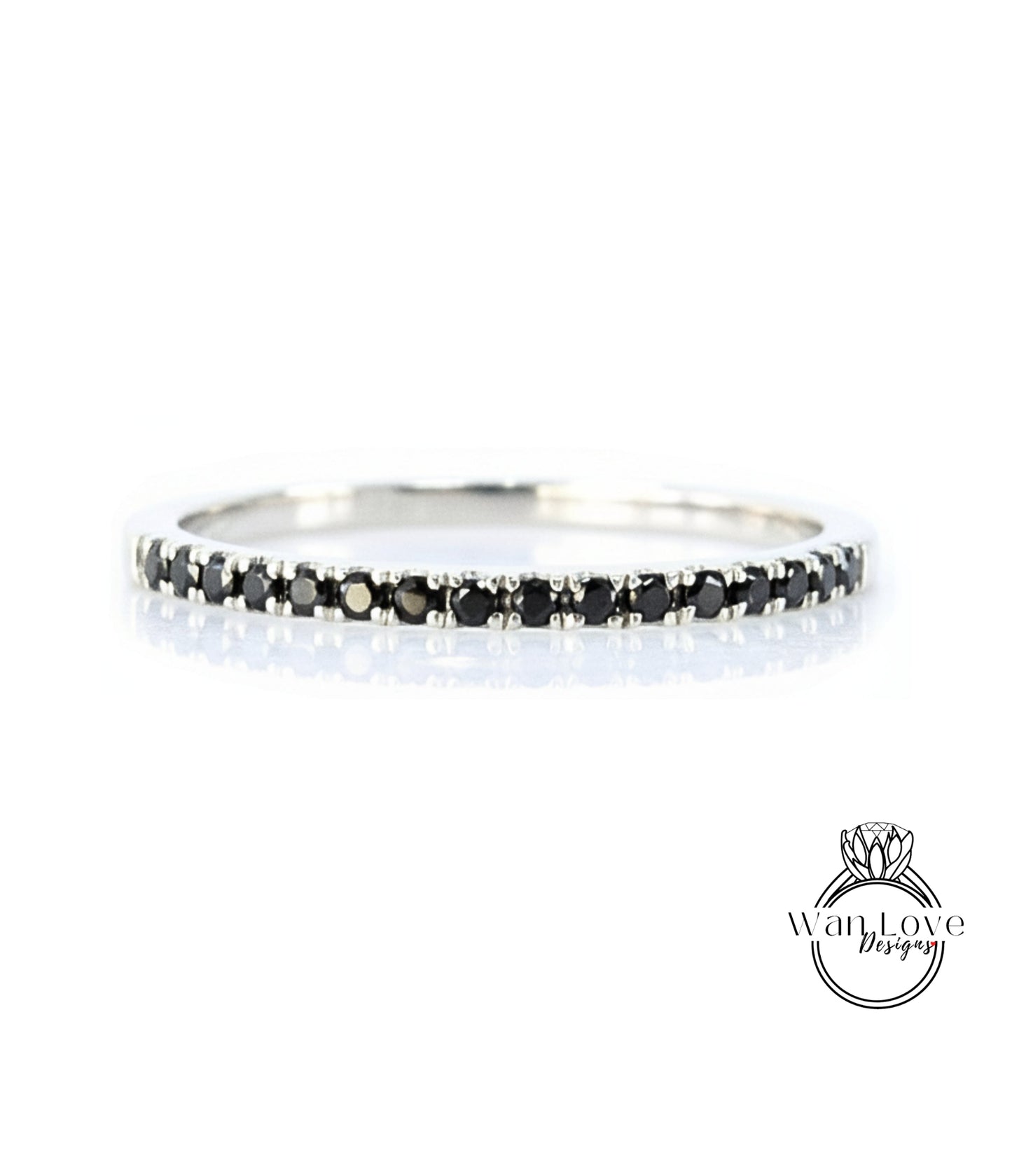 A silver band ring with a row of black diamonds along the edge.