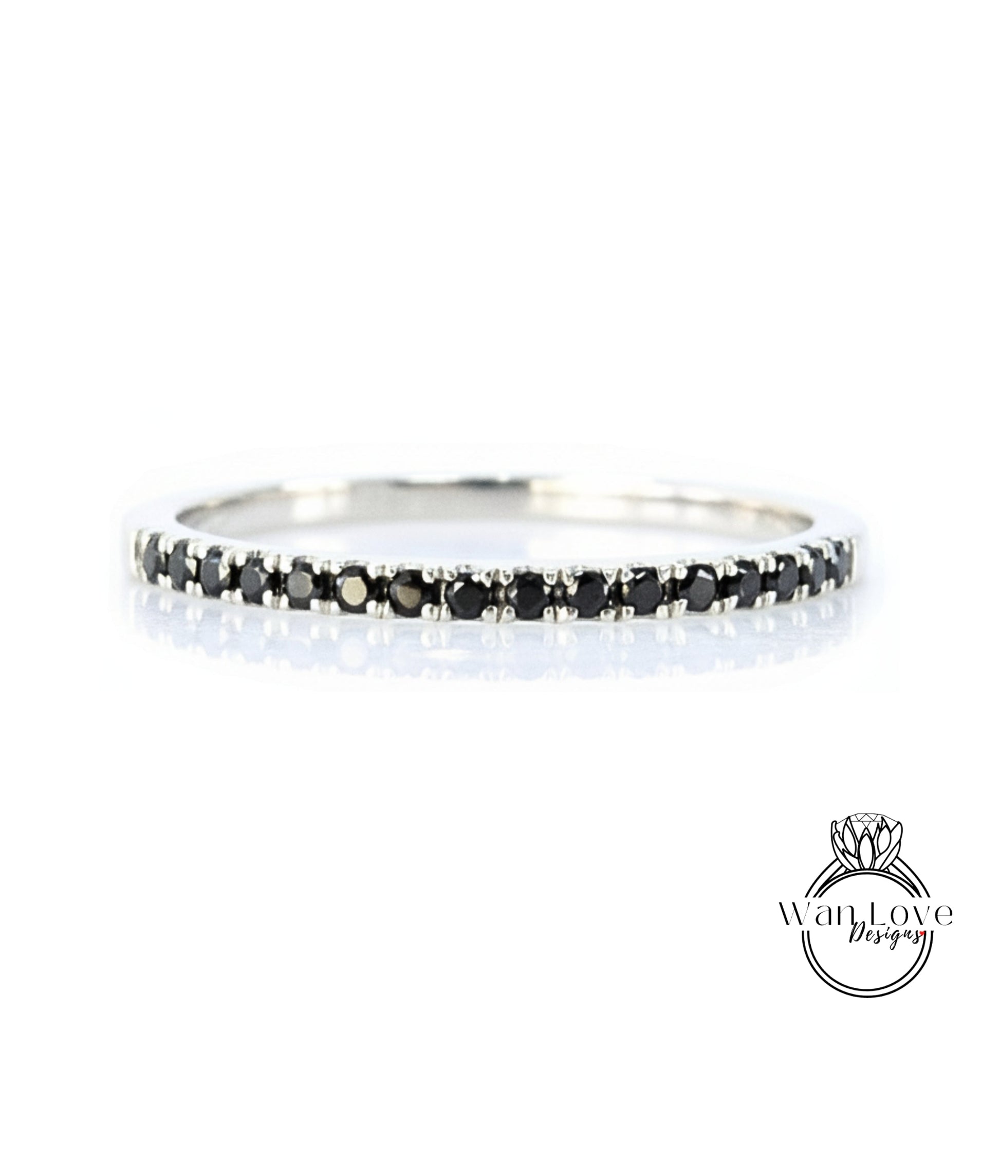 A silver band ring with a row of black diamonds along the edge.