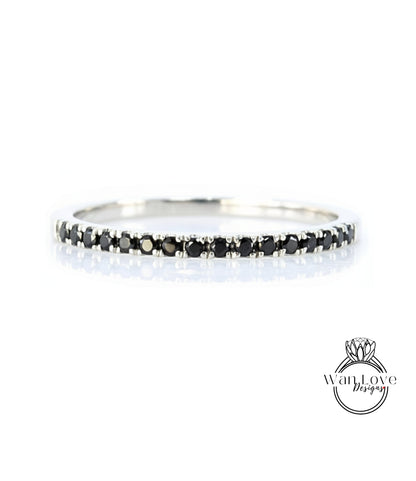 A silver band ring with a row of black diamonds along the edge.
