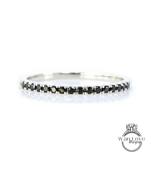 A silver band ring with a row of black diamonds along the edge.