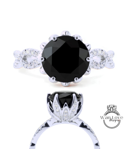 a silver ring with a large black gemstone, likely a diamond, as the centerpiece. The ring is adorned with a floral design and has a unique, elegant appearance.