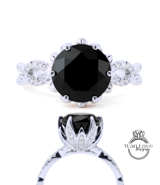 a silver ring with a large black gemstone, likely a diamond, as the centerpiece. The ring is adorned with a floral design and has a unique, elegant appearance.