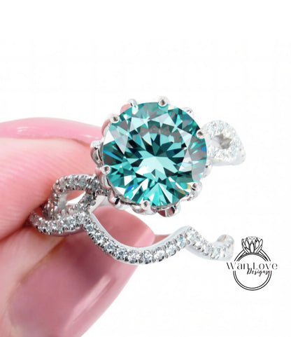 A close-up of a hand holding a silver ring with a large, turquoise-colored gemstone, possibly a diamond.