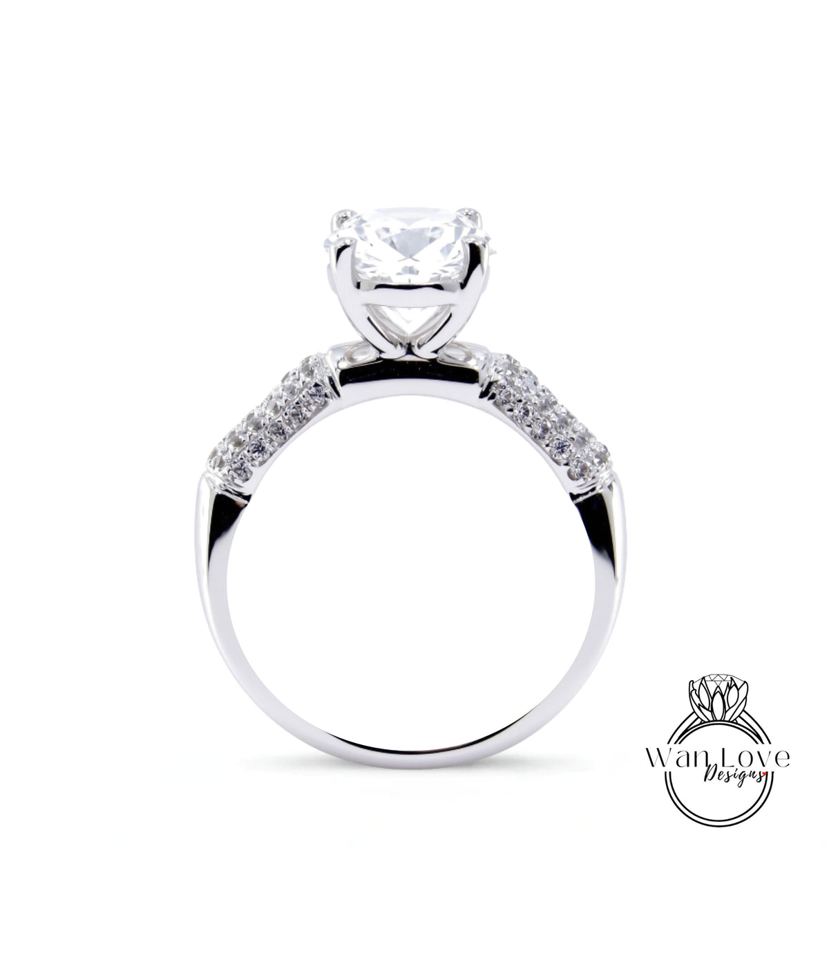 A close-up of a silver engagement ring with a large central diamond and smaller diamonds on either side.