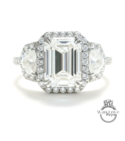 A stunning diamond engagement ring with a large central diamond surrounded by smaller diamonds on either side, set in a halo of smaller diamonds.