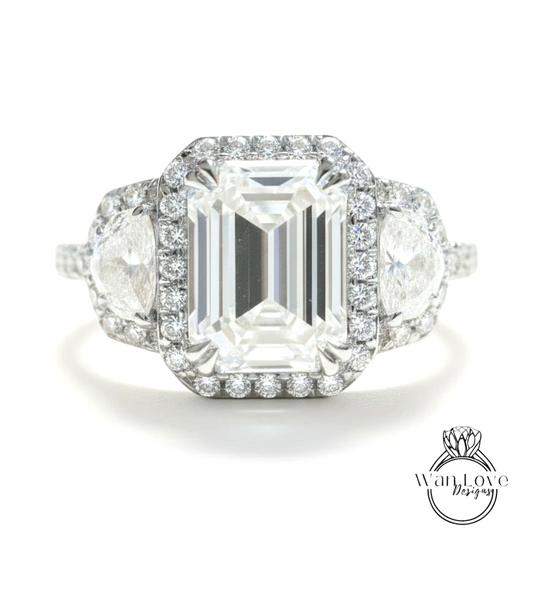 A stunning diamond engagement ring with a large central diamond surrounded by smaller diamonds on either side, set in a halo of smaller diamonds.