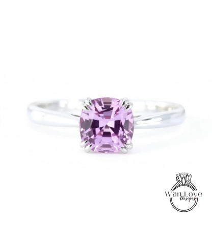 A close-up image of a silver ring with a large, clear, and vibrant purple gemstone, which appears to be a sapphire.