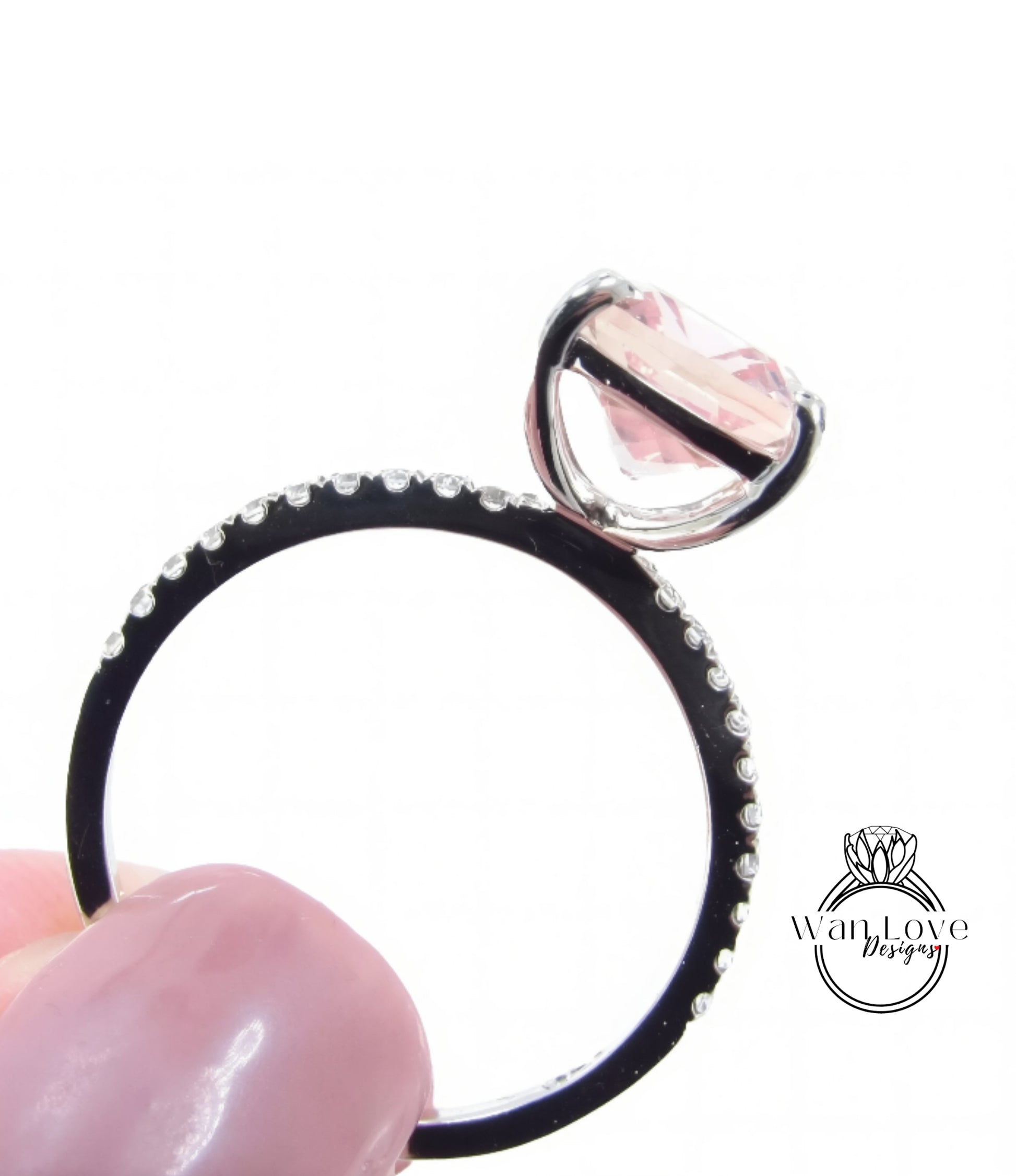 A close-up image of a ring with a large pink gemstone, possibly a diamond, set in a black band with small diamonds.