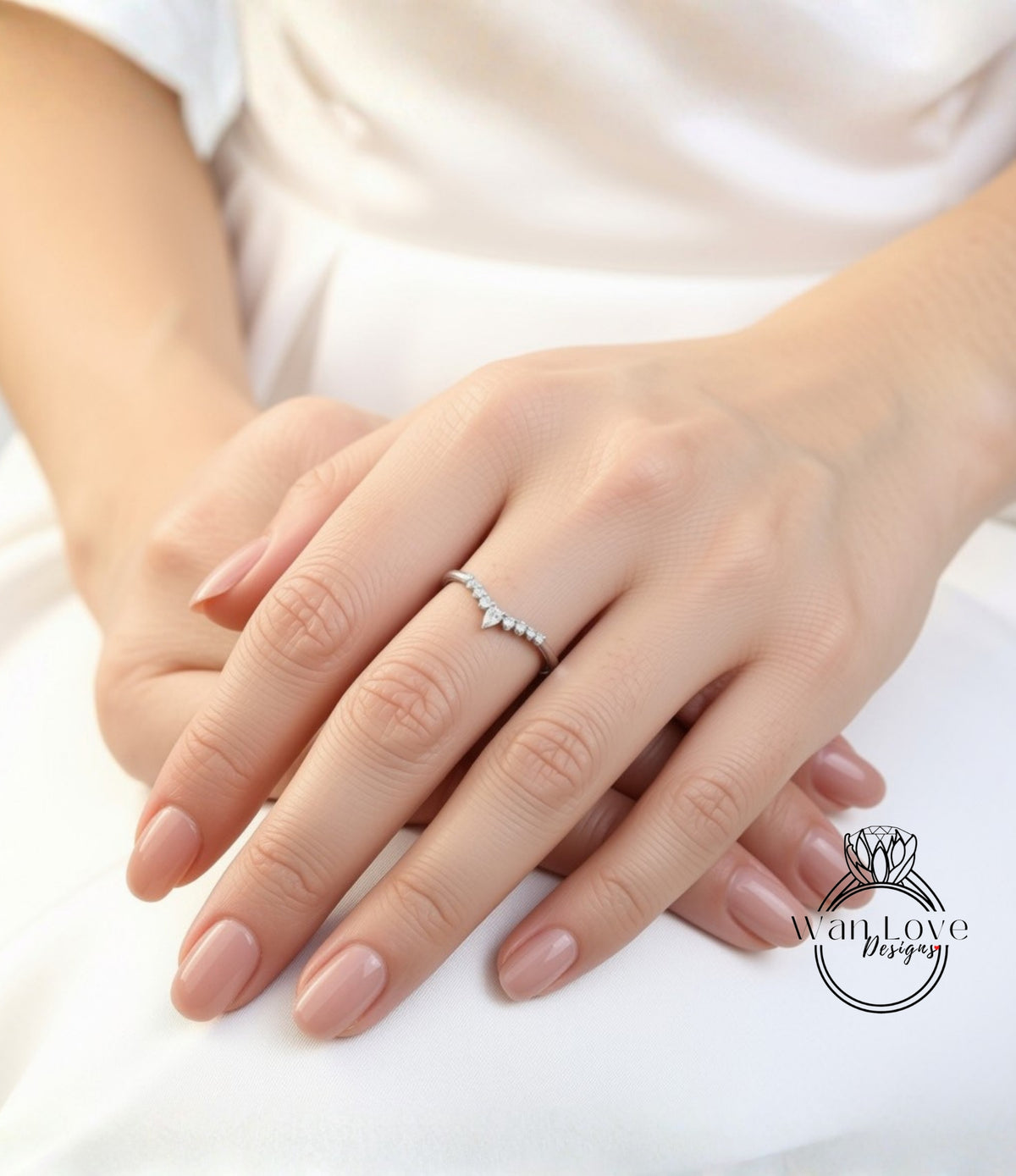 A close-up image of a person's hands wearing a diamond ring.