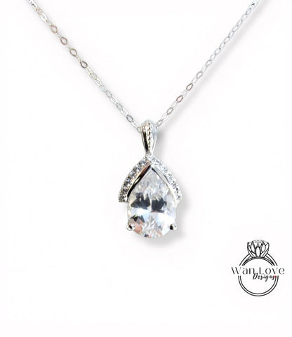 A silver necklace with a large, clear gemstone pendant.