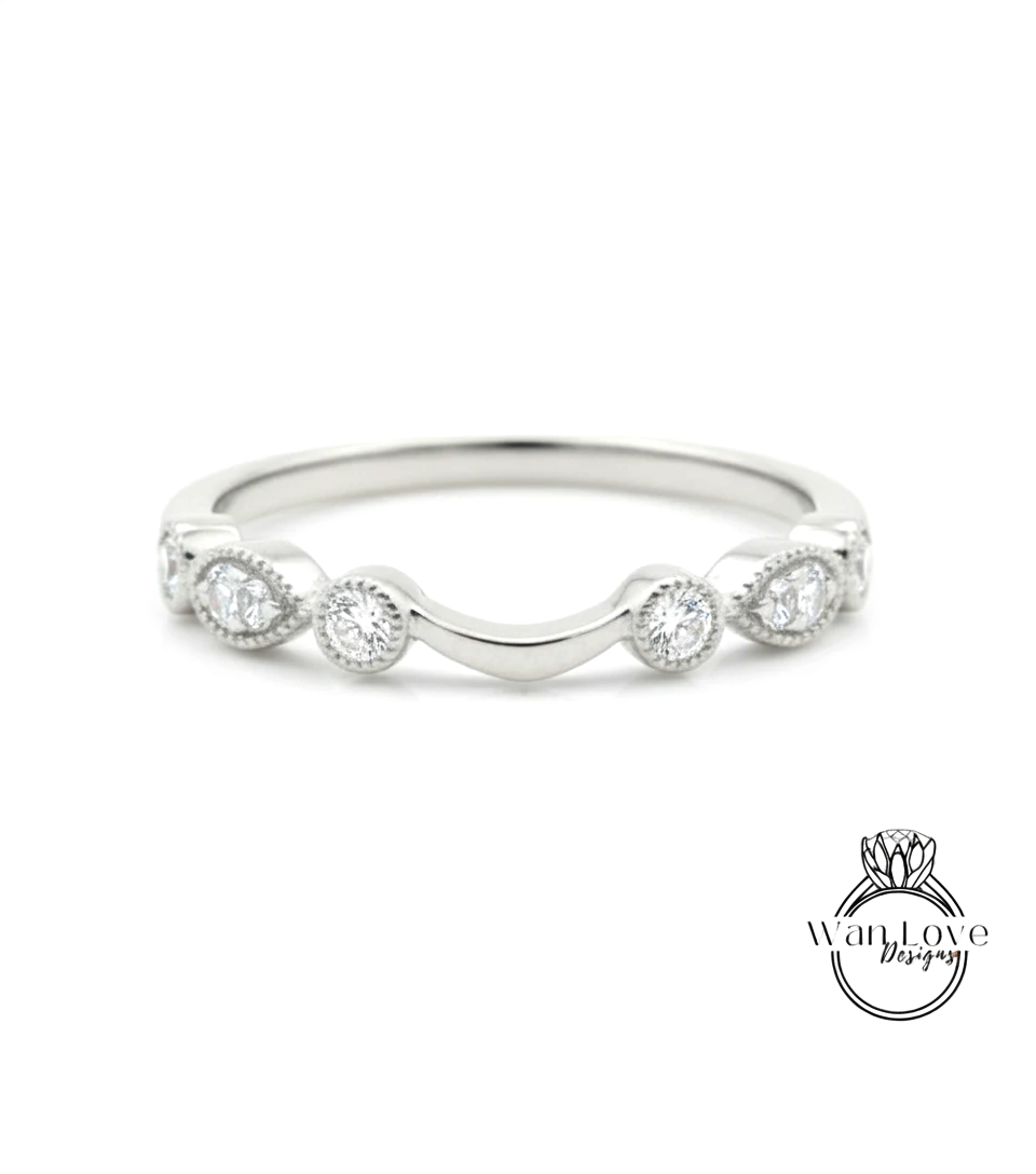 A silver ring with a curved band and a row of small diamonds set in the center.