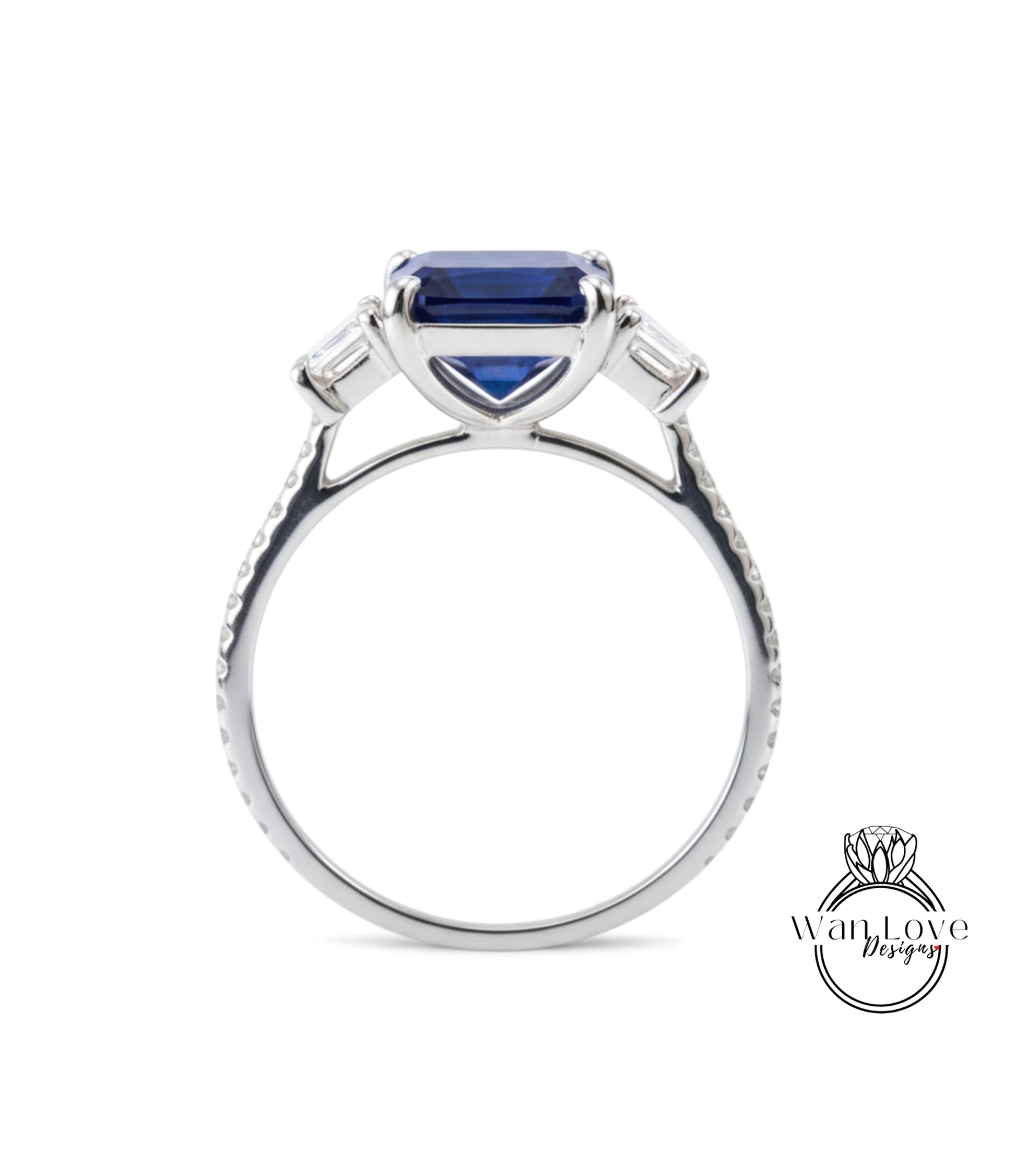 A silver engagement ring with a large blue gemstone, possibly a sapphire, set in a three-pronged diamond design.