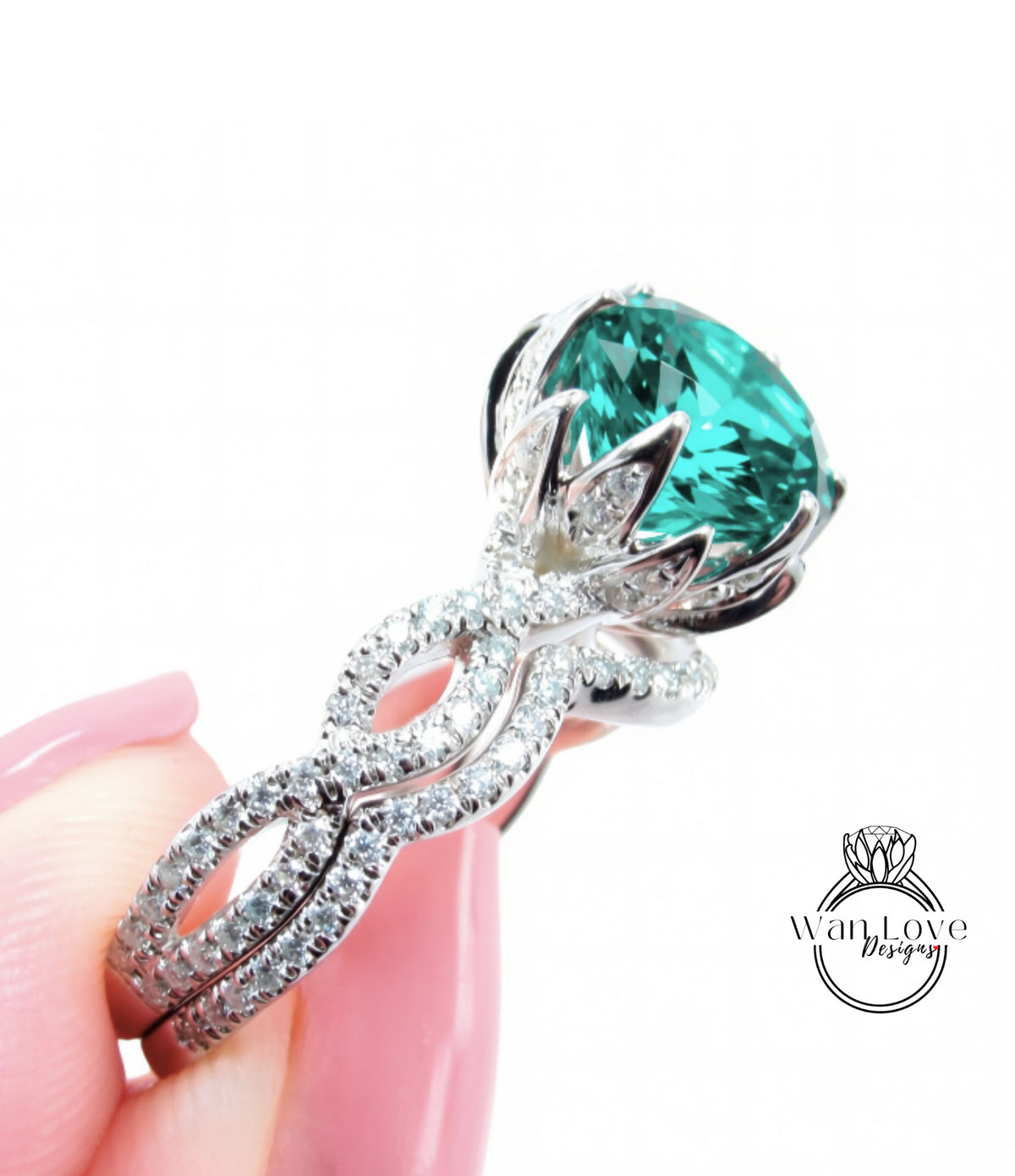 A close-up of a person's hand holding a diamond ring with a large, green gemstone.