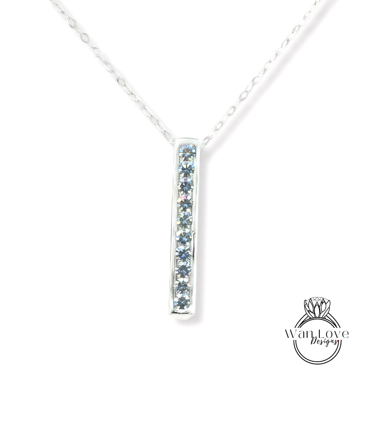 A silver necklace with a pendant featuring a row of blue gemstones.