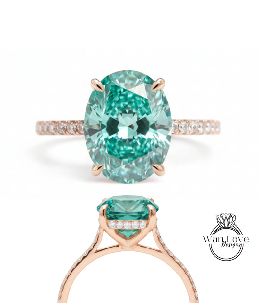 a beautiful engagement ring with a large oval-shaped gemstone set in a rose gold band. The gemstone has a vibrant green color and is surrounded by smaller diamonds, adding to its elegance and sophistication.