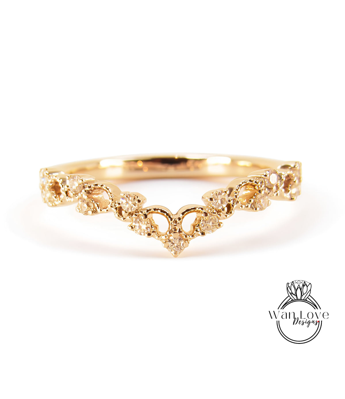 A gold ring with a decorative band featuring a heart-shaped design and small diamonds.