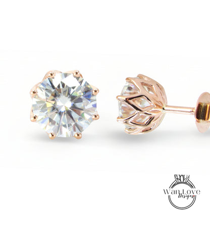 a pair of gold-colored earrings with a large, clear gemstone set in the center.