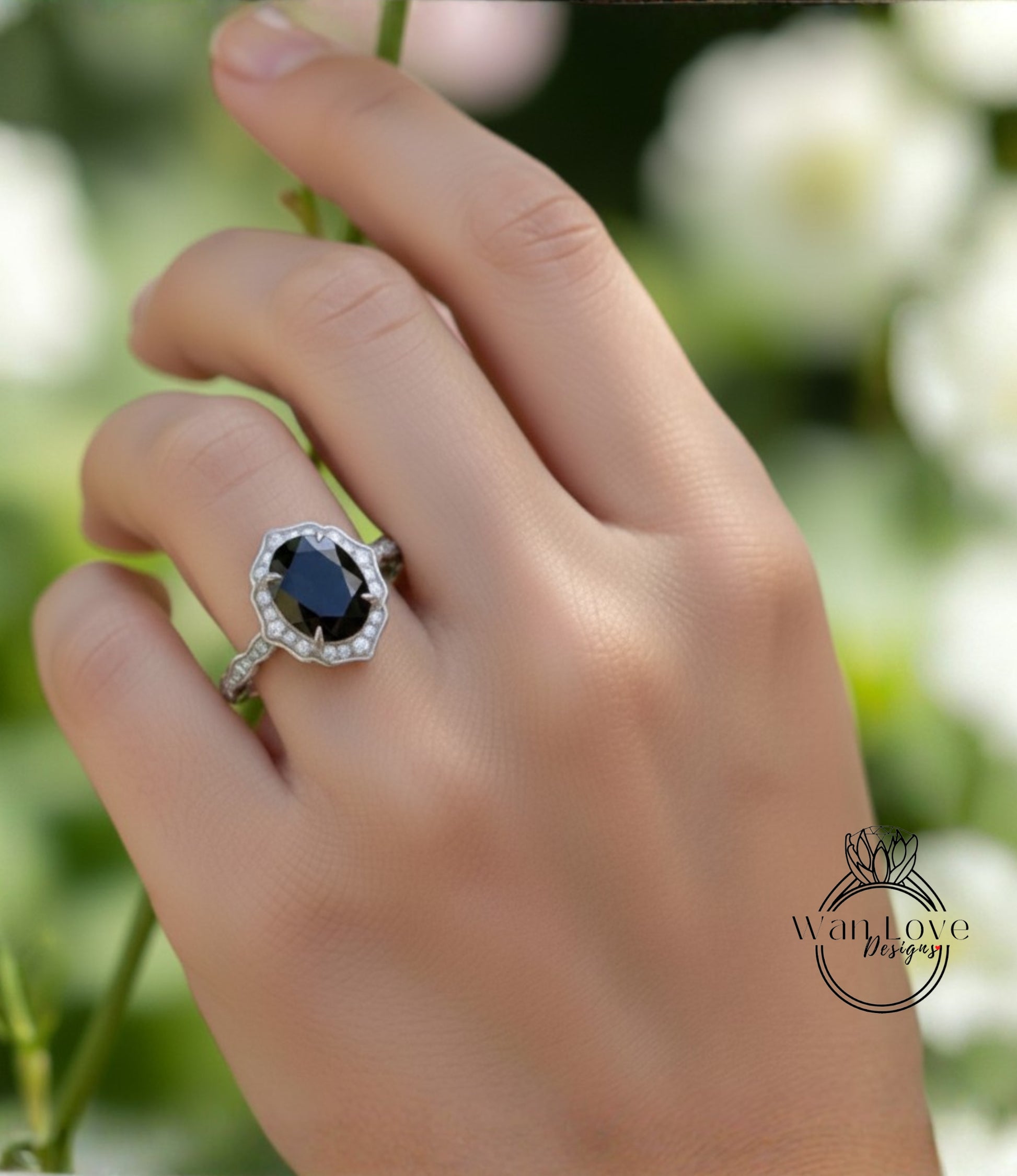 A close-up of a hand wearing a ring with a large black gemstone, likely a diamond, set in a halo of smaller diamonds.