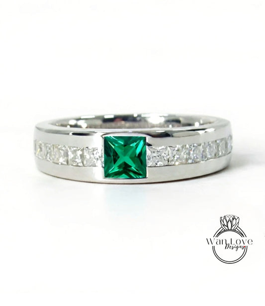 A silver ring with a large green gemstone in the center, surrounded by smaller diamonds along the band.
