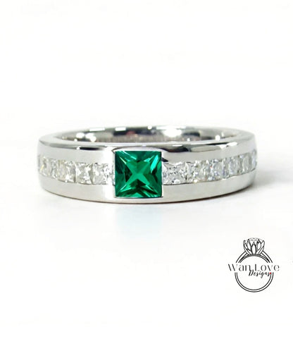 A silver ring with a large green gemstone in the center, surrounded by smaller diamonds along the band.