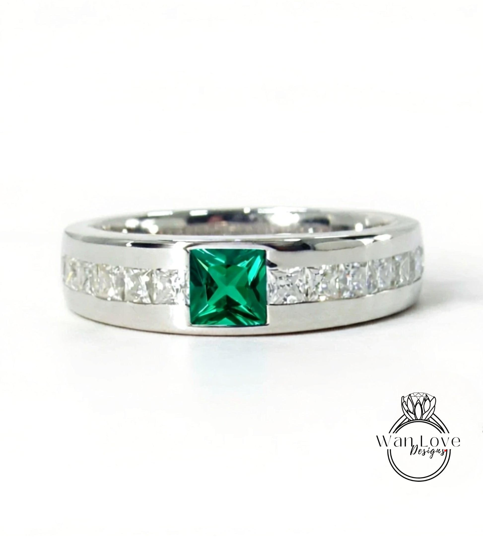A silver ring with a large green gemstone in the center, surrounded by smaller diamonds along the band.