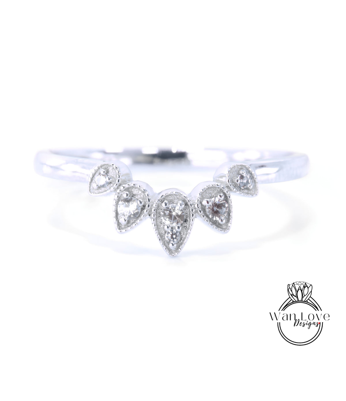 A silver ring with a unique design featuring a central diamond surrounded by smaller diamonds arranged in a fan-like pattern.