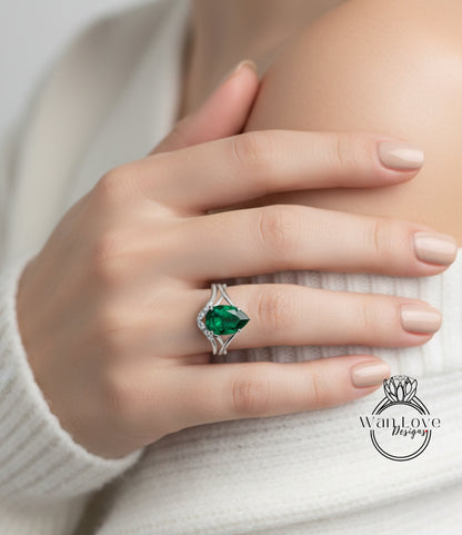 A close-up of a person's hand wearing a ring with a large green gemstone, resting on a white sweater.