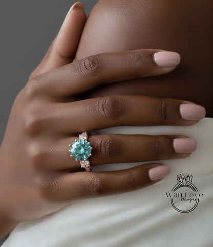 A close-up of a hand wearing a large, turquoise-colored diamond ring with a gold band.