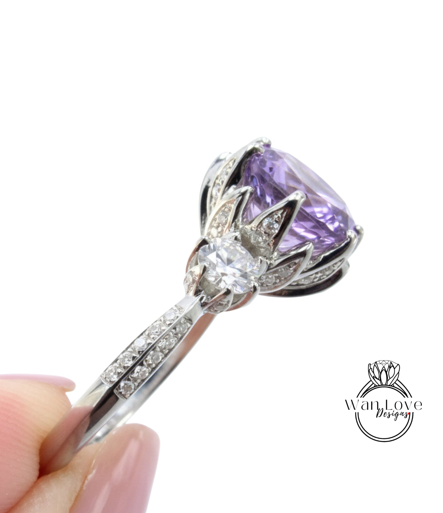 A close-up image of a silver ring with a large purple gemstone, possibly a diamond, and a smaller gemstone.