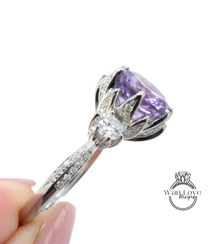 A close-up image of a silver ring with a large purple gemstone, possibly a diamond, and a smaller gemstone.