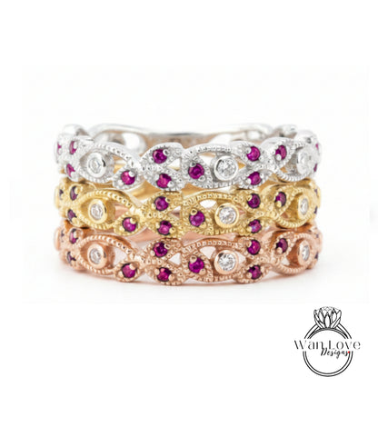 A stack of three rings with various gemstones, including diamonds and rubies, set in different colored metals.