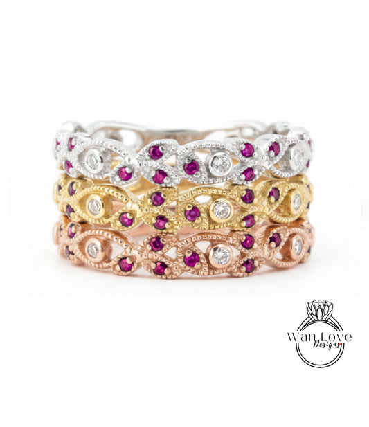 A stack of three rings with various gemstones, including diamonds and rubies, set in different colored metals.