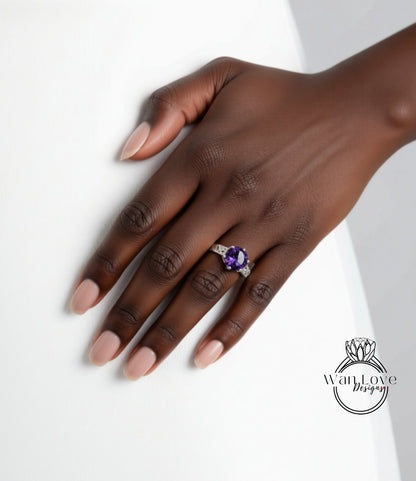 A close-up of a hand wearing a ring with a large purple gemstone.
