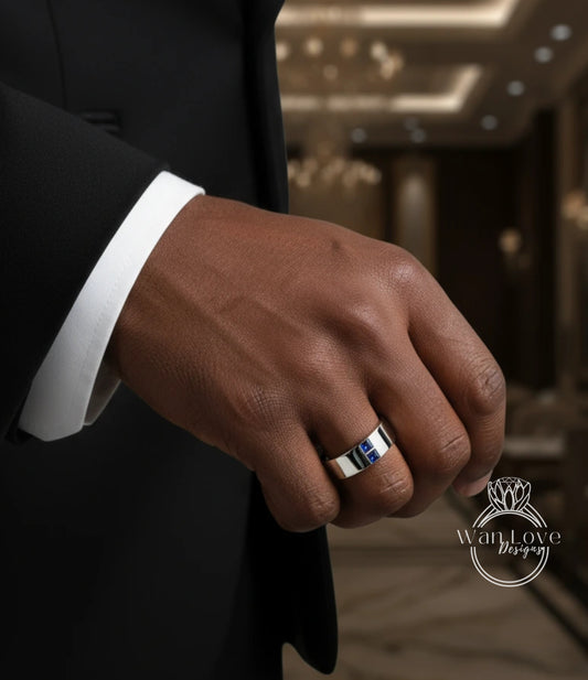 A close-up of a person's hand wearing a silver ring with a blue gemstone.