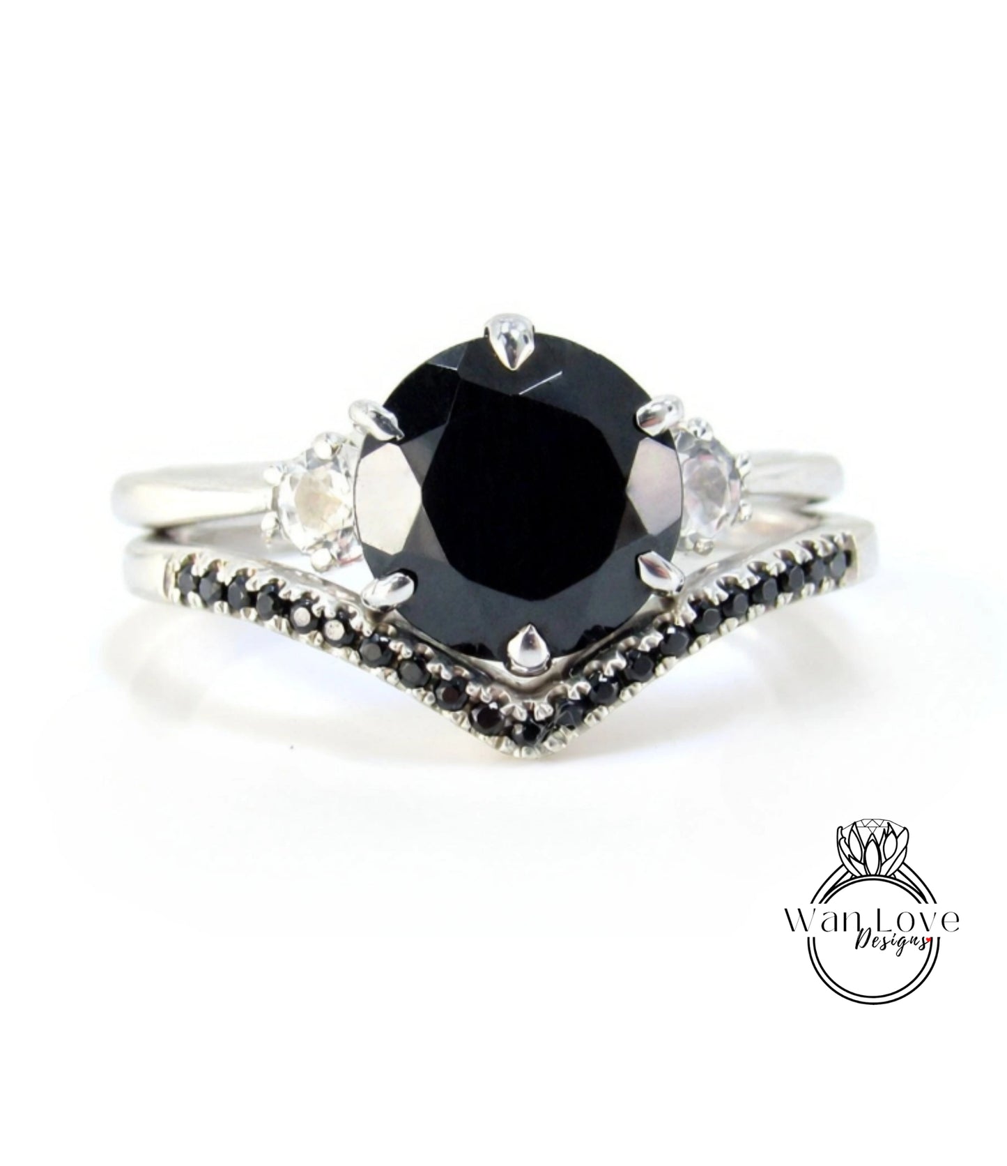 A silver ring with a large black diamond as the centerpiece, surrounded by smaller diamonds.