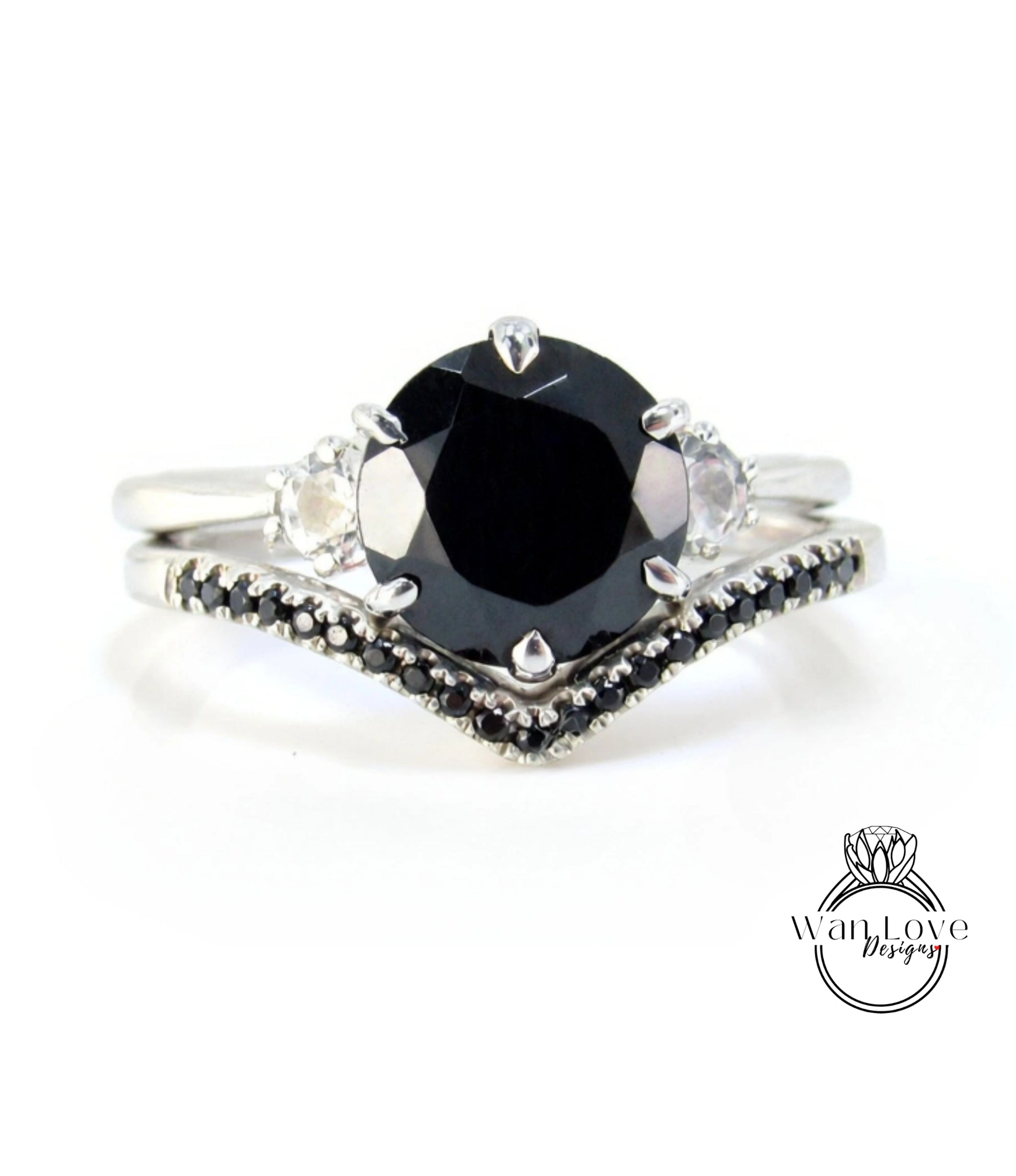 A silver ring with a large black diamond as the centerpiece, surrounded by smaller diamonds.