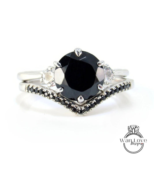 A silver ring with a large black diamond as the centerpiece, surrounded by smaller diamonds.