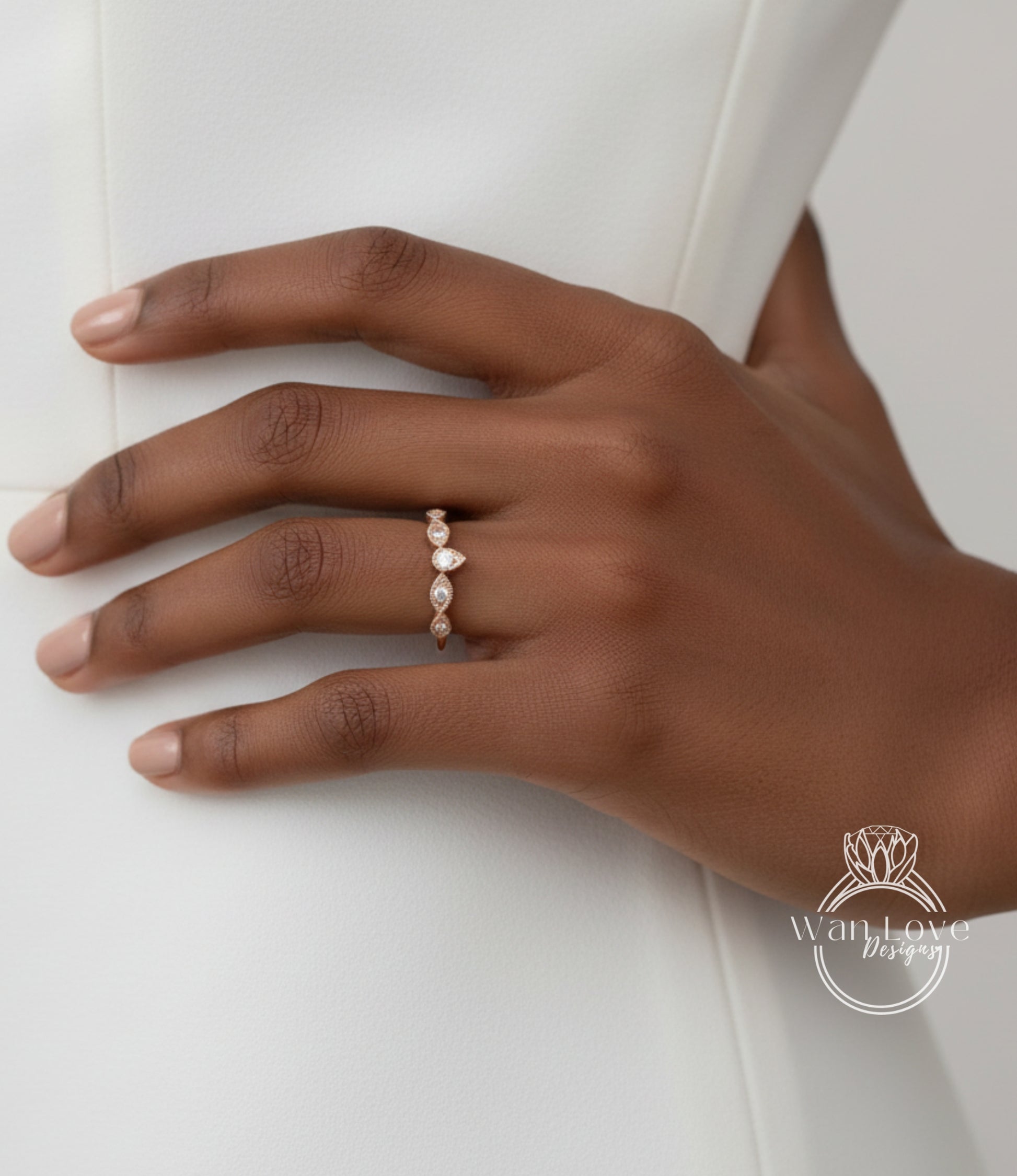 A close-up of a hand wearing a gold ring with a row of small diamonds.