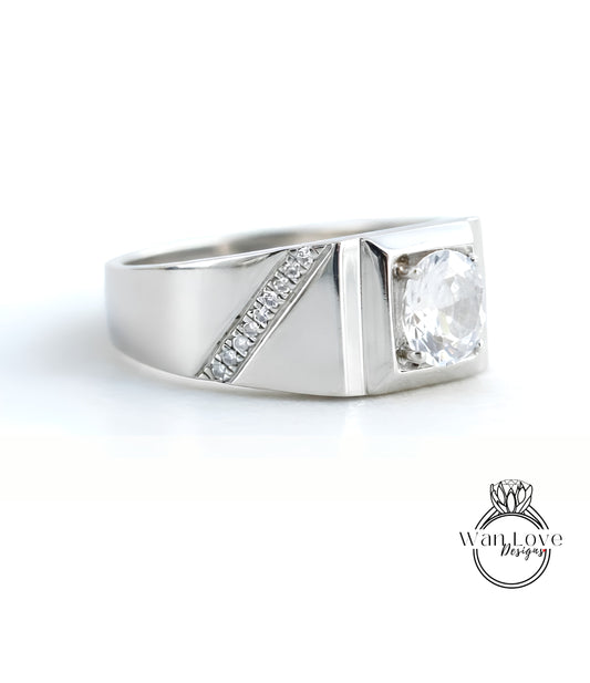 A silver ring with a large central diamond and a smaller diamond accent on the side.