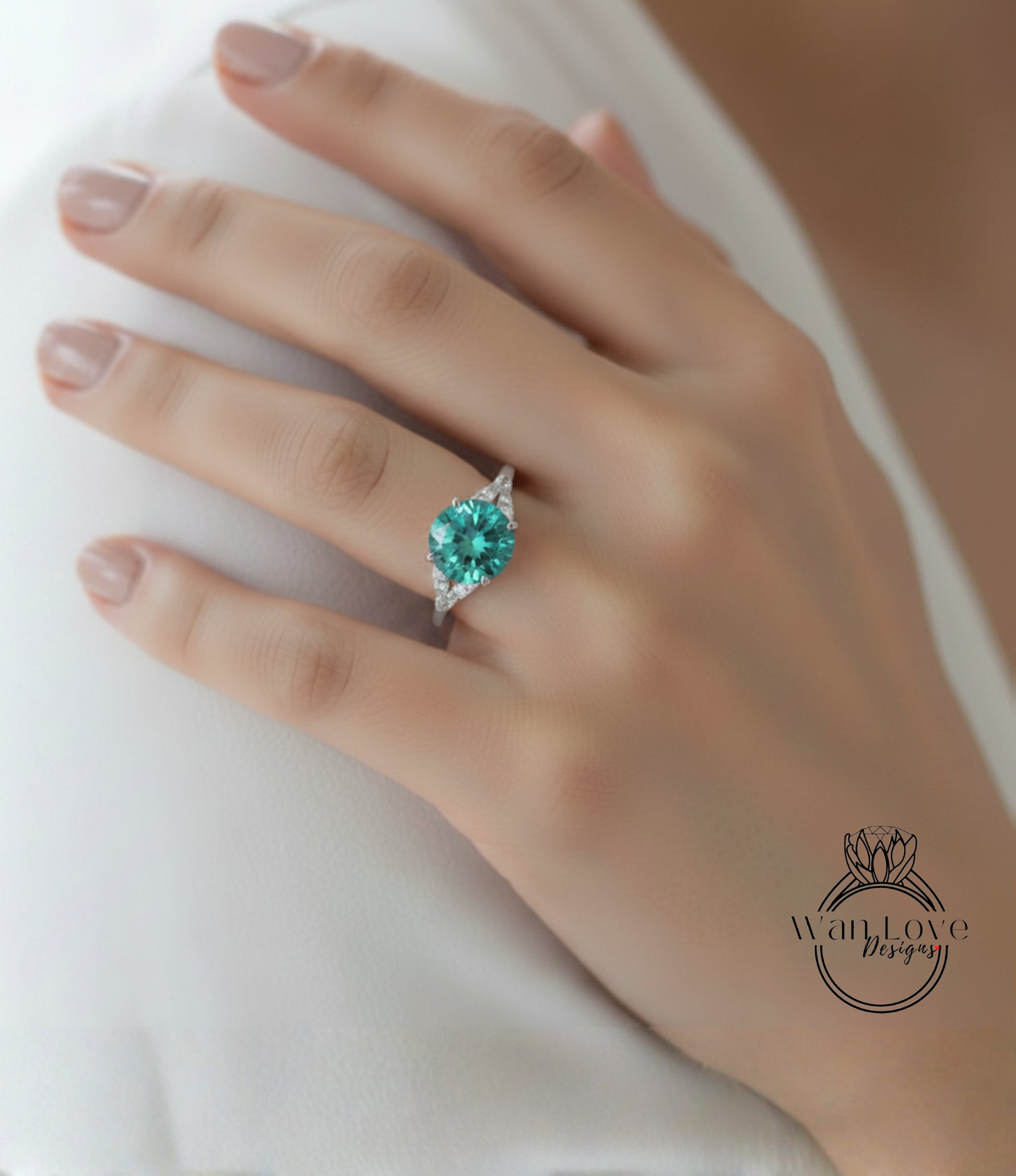 A close-up of a hand wearing a ring with a large, green gemstone.
