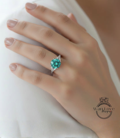 A close-up of a hand wearing a ring with a large, green gemstone.