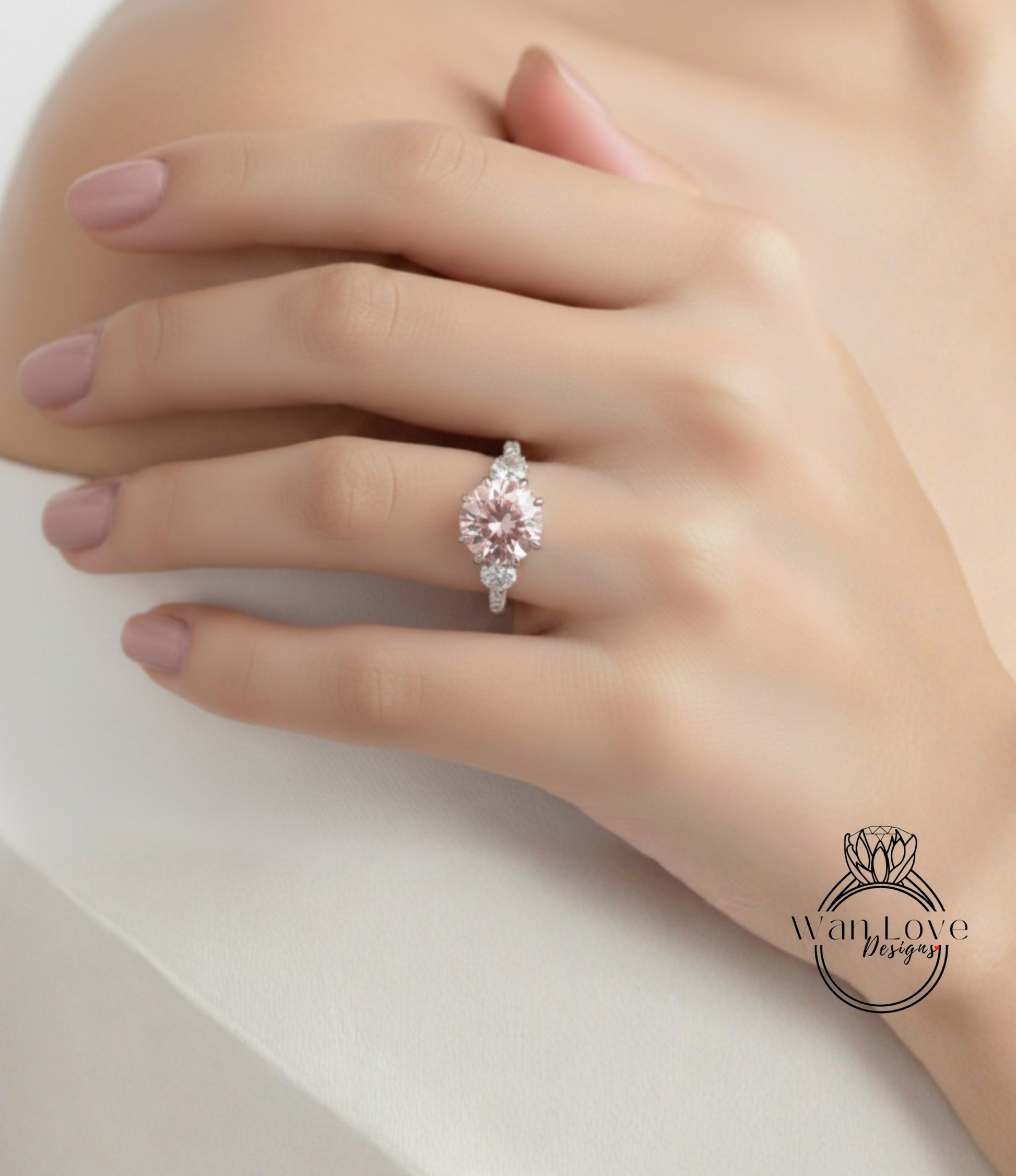 A close-up of a hand wearing a pink diamond engagement ring.