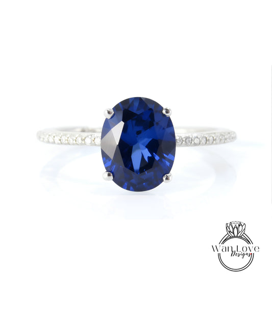 A close-up image of a diamond engagement ring with a large oval-shaped blue gemstone set in a silver band.