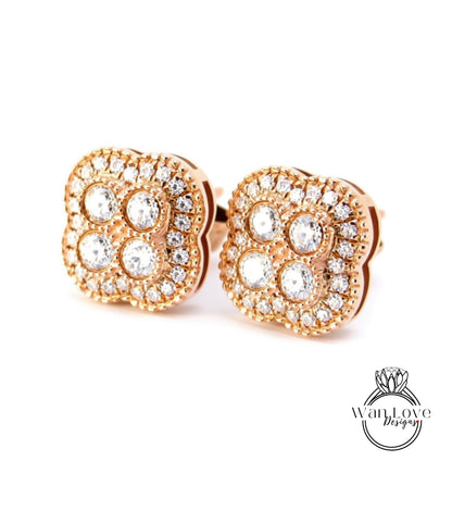 A pair of gold earrings with a large, intricate design of small diamonds set in the center.