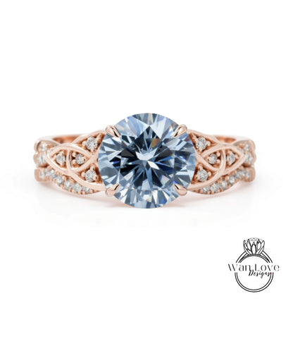 A rose gold engagement ring with a large blue diamond as the centerpiece, surrounded by smaller diamonds and intricate designs.