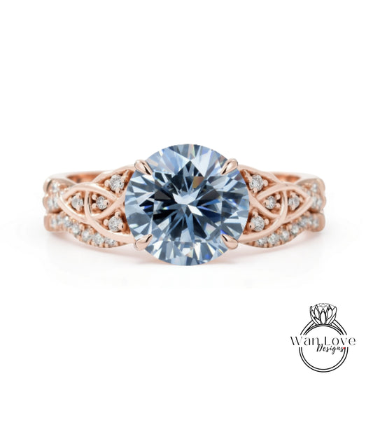 A rose gold engagement ring with a large blue diamond as the centerpiece, surrounded by smaller diamonds and intricate designs.