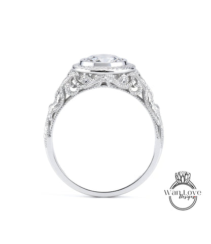 A close-up view of a silver ring with an intricate, decorative design around the band and a large central stone.